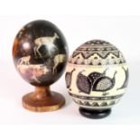 Two hand painted ostrich eggs, both depicting animals, one mounted to a turned wood stand