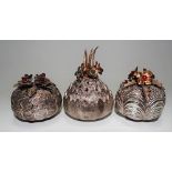 Three modern silver ovoid novelty pepperettes with stone inset gilt flowers by Christopher Nigel