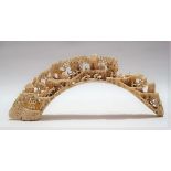 Chinese carved boar tusk profusely carved and pierced with a village scene, length 23.5cm