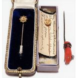 15ct gold head diamond set tie pin within original box; together with a 9ct gold tie pin and a coral