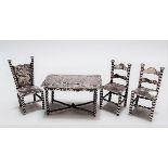 Victorian silver embossed miniature table; together with three silver miniature chairs (4).