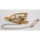 Victorian 15ct hallmarked gold brooch in the form of a wishbone with bird on branch, hallmarked