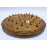 Early Victorian circular solitaire board with thirty two turned bone pegs, the back inscribed '