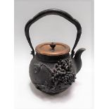 Japanese swing-handled tetsubin (cast iron tea kettle) with bronze lid, the brass lid with seed