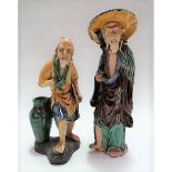 Two Chinese earthenware figures of elderly gentlemen, height of largest 27cm (both af).