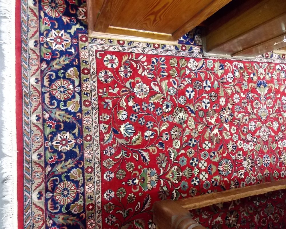 Modern Persian wool hand knotted rug, profusely foliate decorated within multiple borders upon a red