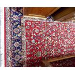 Modern Persian wool hand knotted rug, profusely foliate decorated within multiple borders upon a red