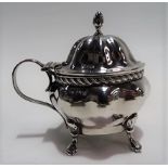 Edwardian silver hinge lidded mustard pot, of ovoid lobed form, the lid with acorn finial and raised