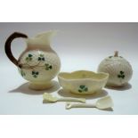 Belleek porcelain shamrock moulded cream jug, condiment pot and a lobed salt with spade shaped spoon