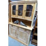 Victorian stripped pine dresser, the slightly bowed top with three glazed doors, the base with three