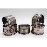 Four silver hallmarked napkin rings; together with a Chinese white metal napkin ring, weight overall