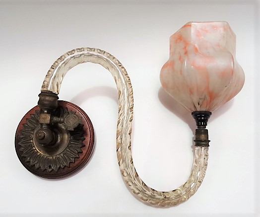 A wall mounting brass light fitting with glass arm and opaque marbled glass shade