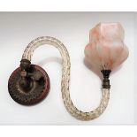 A wall mounting brass light fitting with glass arm and opaque marbled glass shade