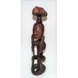 Tribal stylised hardwood figure depicting a seated figure with animal on its head, height 39cm.