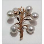 14k gold, baroque pearl and diamond set brooch modelled as a branch issuing berries, the brilliant