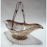 Edwardian silver swing handled bread basket, the handle with three flowerhead boss, with beaded