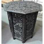 Eastern octagonal carved wood folding table, with grape and vine scrolled top, the folding base with