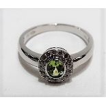 A contemporary 18ct white gold peridot and diamond cluster ring, weight 4.5g approx