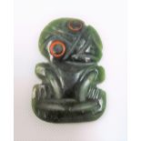 Green carved jadeite Tiki, the eyes coloured with red, height 45mm.