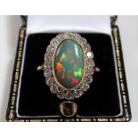 Good 18ct gold opal and diamond cluster ring, the opal of 3ct spread approx and displaying colours