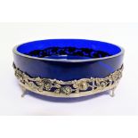 White metal and blue cobalt glass dish, the white metal pierced and embossed with full scrolls and