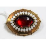 19th Century gold, white enamel & red paste set oval brooch, the back with glazed panel, width 35mm,