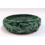 Mottled green jade bangle, carved with two rabbits amongst leaf scrolls, diameter 7.5cm.