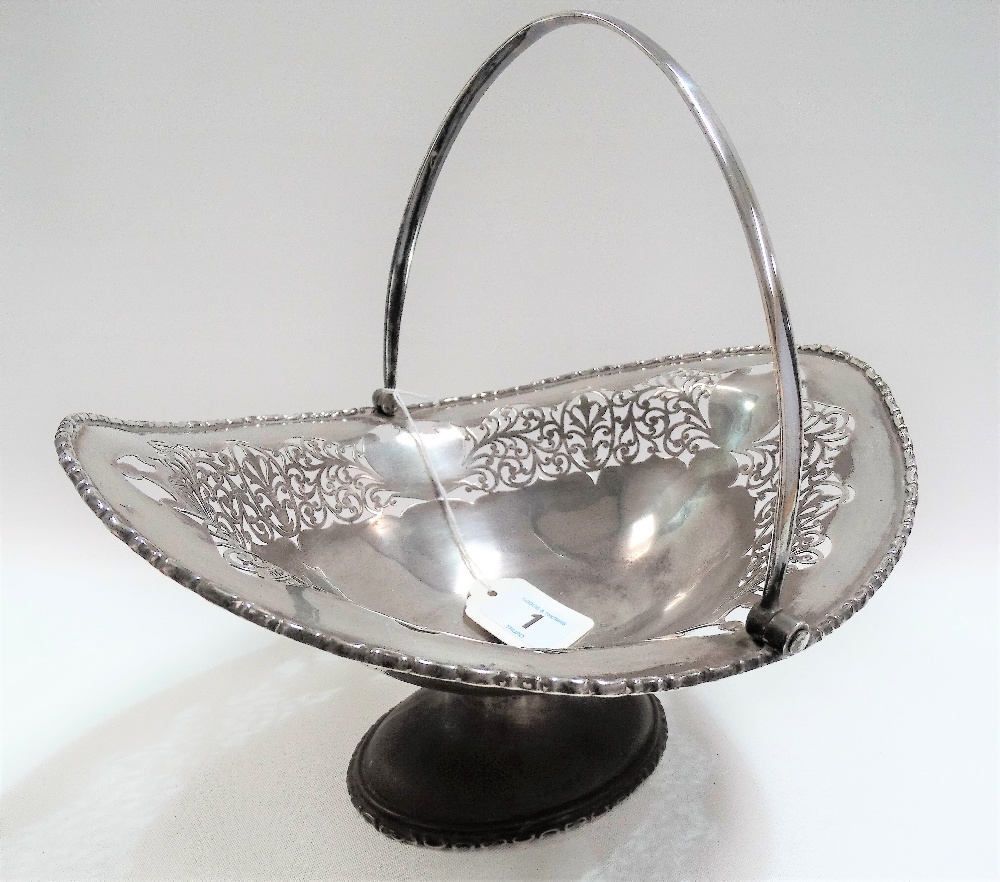 George VI silver fruit bowl with swing handle and foliate scroll pierced, upon oval pedestal,