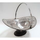 George VI silver fruit bowl with swing handle and foliate scroll pierced, upon oval pedestal,