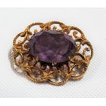 Yellow metal foliate scroll openwork amethyst set brooch, width 25mm, weight 4.6g approx.