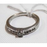 Modern 18ct hallmarked white gold diamond ring with larger central diamond measuring 0.10ct spread