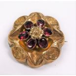 Victorian gold pink sapphire set brooch, set with six oval cut sapphires around a flowerhead, the