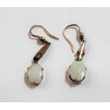 Pair of gold mounted oval white opal drop earrings with green, purple & orange flashes, the opals of