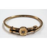 Victorian yellow metal crossover bangle with central panel set with a diamond of 0.07ct spread