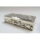 Edwardian silver rectangular embossed box by William Comyns, decorated with three cherubs to the