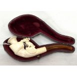 A Meerschaum pipe with ivory mouthpiece, the bowl carved as a dog and horse hoof, within fitted
