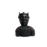 An African tribal bust figure carved as a warrior wearing armour, height 23cm.