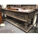 Antique oak low dresser, the moulded top over three carved drawers and gadrooned moulding and open
