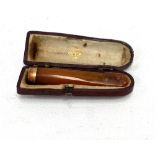 An amber cheroot holder with 9ct hallmarked gold band and within fitted case.