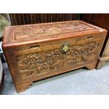 Chinese carved camphor wood blanket box hinged to reveal a sliding tray, profusely carved with