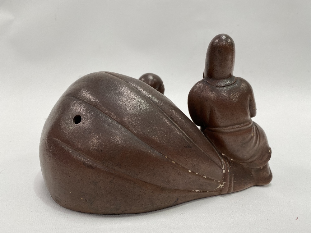 A Chinese stoneware Yixing group modelled as a reclining jovial Buddha against a pillow with - Image 2 of 2