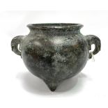 A Chinese bronze ovoid pot with twin elephant ring handles and raised on triple feet, four character