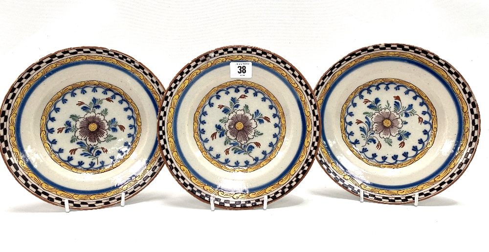 A set of three 18th century polychrome Delft dishes, each painted with a flower to the centre,
