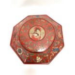 A Chinese red lacquer octagonal lidded box, the lid decorated with a bird amongst chrysanthemum