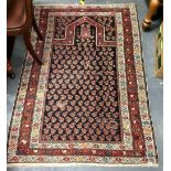 Caucasus prayer rug with Boteh motifs within borders upon a dark blue ground, 172cm x 118cm.
