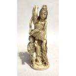 A Japanese Meiji period ivory okimono, carved as a female and boy holding a feather cloak, signed to
