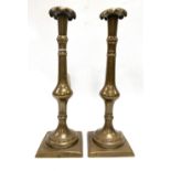 A pair of 19th century brass baluster candlesticks, the sconce with lobed edge, both with stamped