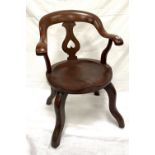 An early 20th century mahogany office swivel chair upon four legs.