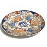 Pair of Japanese Imari chargers, each decorated with panels of rocks issuing flowers & a central