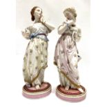 A pair of 19th century Paris Vinonet & Baurey painted bisque porcelain lady figures, both holding